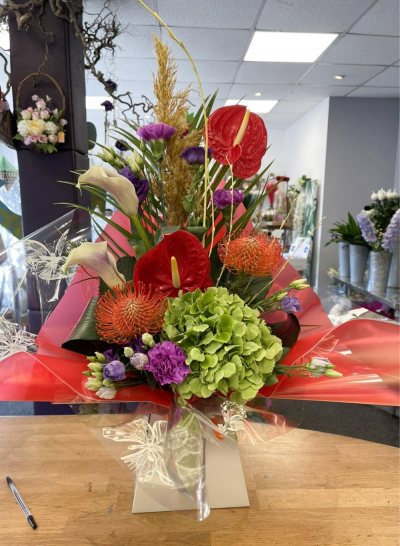 Hidden Treasure - An outstanding hand tied bouquet with a cascade of colour and a treasure chest overflowing with the beautiful flowers.